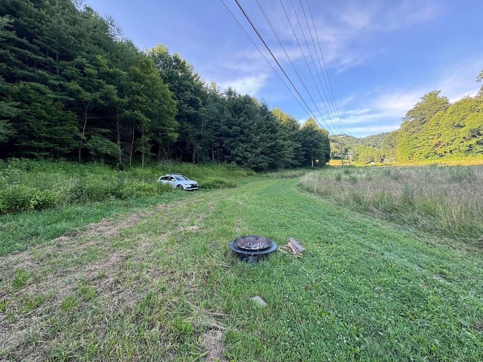 Tent pitched on farm pasture with mountain backdrop at Shipley Farms