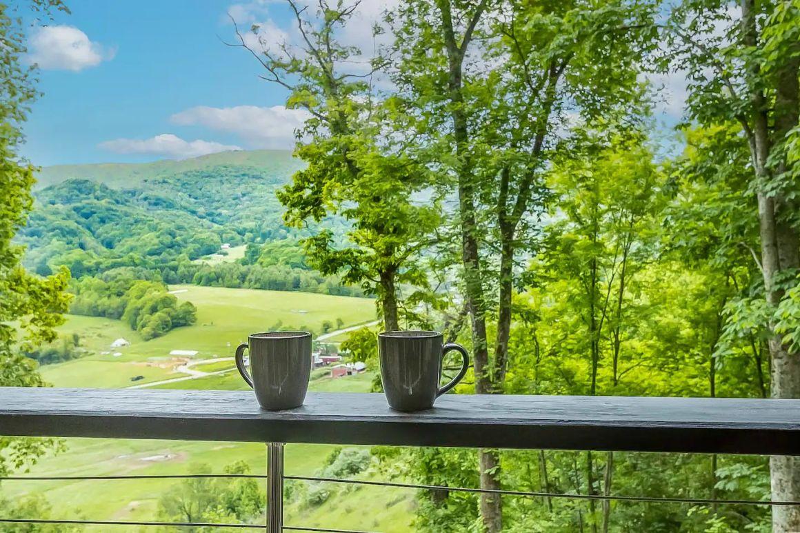 Luxury glamping tent porch with coffee and wine overlooking the mountain valley