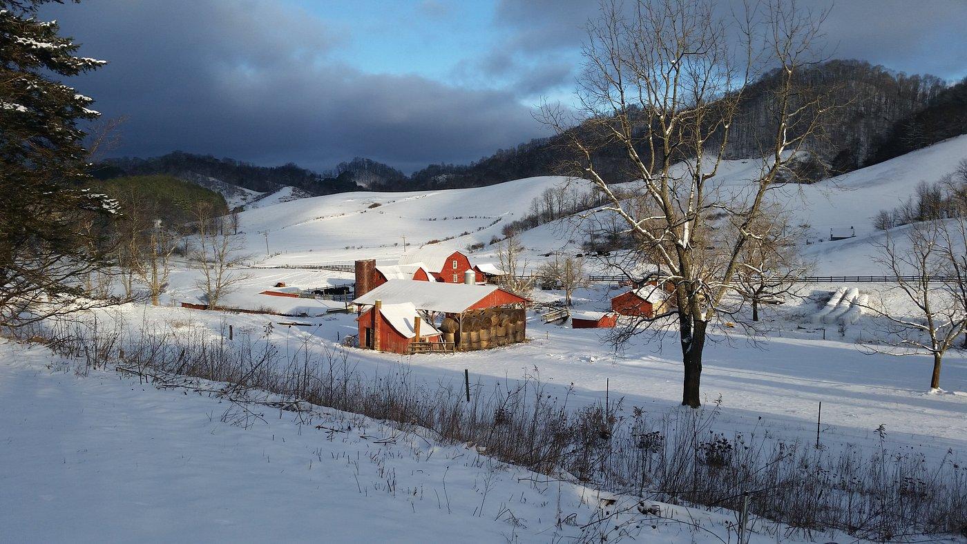 Shipley Farms in winter, the red barn and snow-covered pastures with mountain ridges in the background
